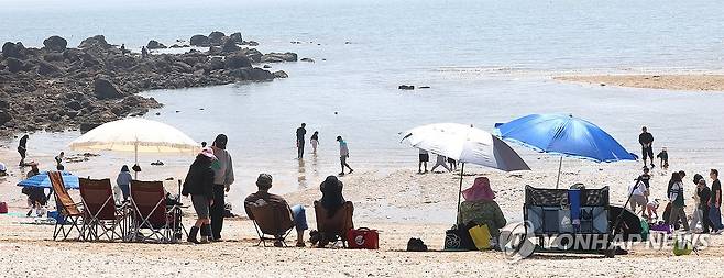 파라솔 아래 더위식히는 시민들 (인천=연합뉴스) 임순석 기자 = 초여름 날씨를 보인 19일 인천 중구 선녀바위 해수욕장을 찾은 시민들이 더위를 식히고 있다. 2026.4.19 soonseok02@yna.co.kr