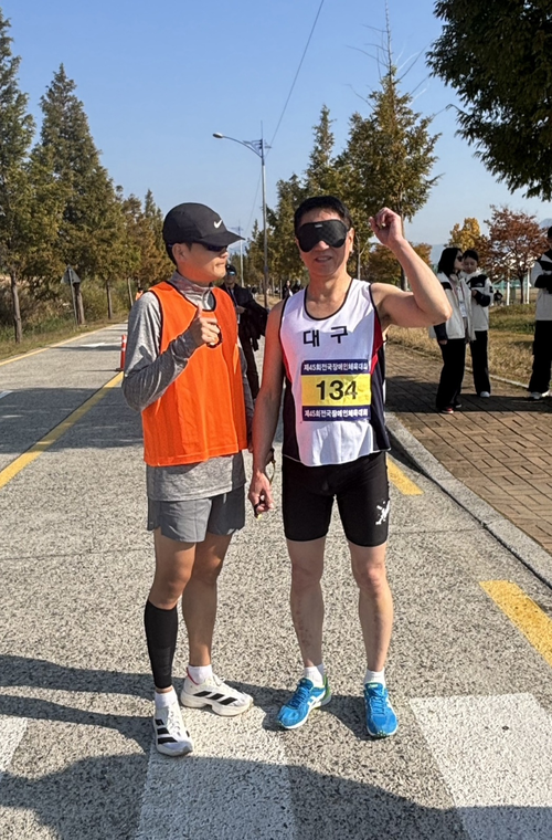 지난해 10월 부산 연제구 대저생태공원 일대에서 열린 제45회전국장애인체육대회 육상부문에 출전한  시각장애인 임승호씨가 트랙위에서  가이드러너와 함께 기념사진을 촬영하고 있다. 임승호씨 제공