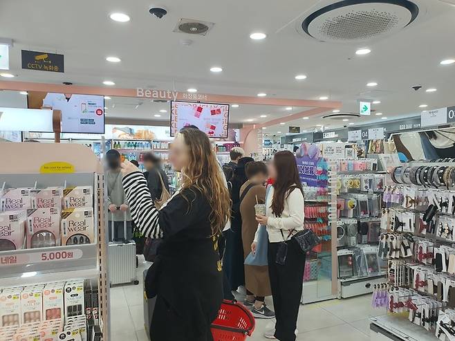 다이소 명동역점에서 외국인 관광객들이 한국 화장품을 살펴보고 있다./사진=오진주 기자