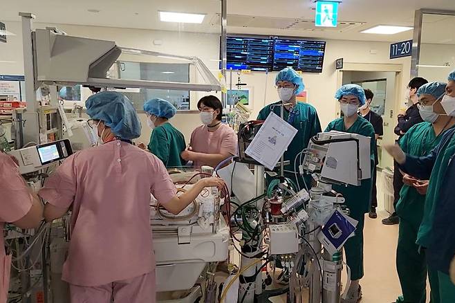 서울아산병원에서 신생아과 의사와 간호사, 인공심폐기사 등 10명 이상의 의료진이 투입돼 에크모 기계와 인공호흡기를 연결한 신생아 환자를 수술장으로 이동하고 있다.(사진제공=서울아산병원)