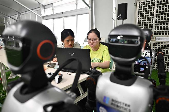 지난해 8월 4일(현지시간) 베이징에서 중국 학생들이 휴머노이드 로봇을 살펴보고 있다. AFP=연합뉴스