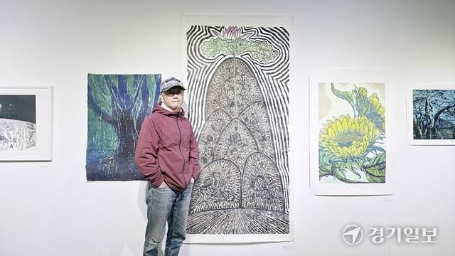 류연복 작가가 자신의 작품 ‘꽃한송이’(2025)와 함께 기념촬영을 하고 있다. 류 작가는 목판화를 ‘시의 언어’라고 표현했다. 이나경기자