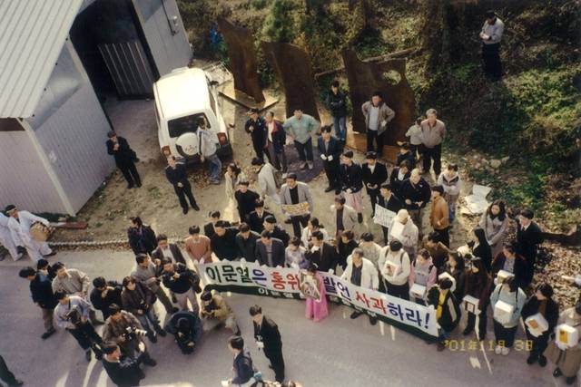 지난 2001년 경기 이천 이문열 작가 집 앞에서 열린 책 장례식 장면. 피켓을 든 어른들 앞에서 한 소녀가 영정을 들고 서 있다.  ⓒ이재유