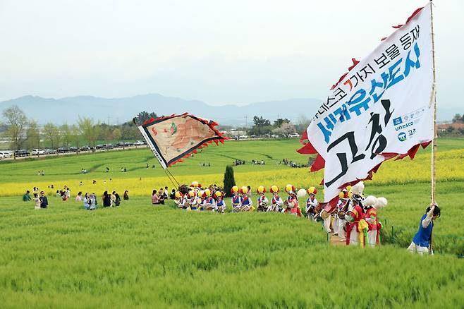 [고창=뉴시스] 지난 18일 고창군 공음면 학원농장에서 제23회 청보리밭축제가 개막했다. 고창청보리밭축제 상징깃발을 든 기접놀이패와 농악단이 보리밭 사잇길을 지나고 있다. *재판매 및 DB 금지