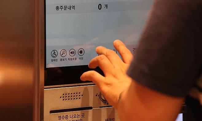 무인주문기 한켠 직원 호출 버튼을 확인하지 못하고 주문 중인 시각장애인. 연합뉴스