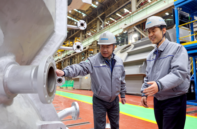 박정원 두산그룹 회장(왼쪽)이 지난 2월 11일 경남 창원 두산에너빌리티 사업장을 방문해 제작 중인 발전용 가스터빈 제품을 살펴보고 있다. [사진=두산]