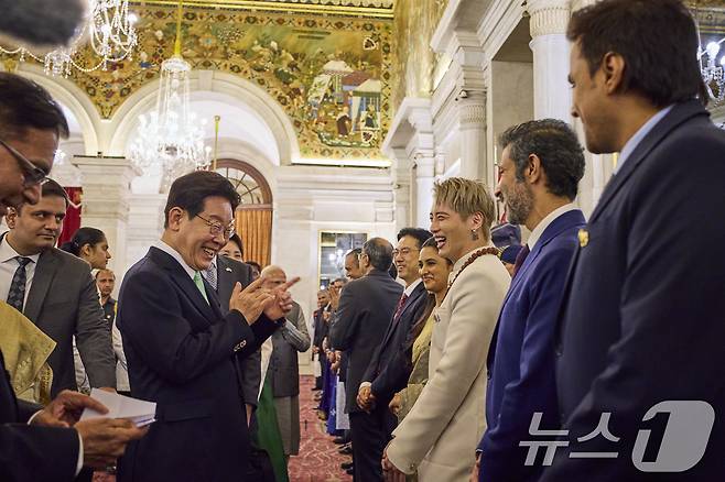 이재명 대통령이 20일 인도 뉴델리 대통령궁에서 드로우파디 무르무 인도 대통령 주최 국빈 만찬에 참석한 가수 아우라(박민준)와 인사하고 있다. (공동취재) 2026.4.21 ⓒ 뉴스1 이재명 기자