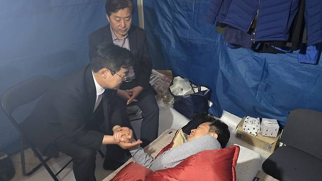 박찬대 민주당 인천시장 후보(시계방향 왼쪽)과 황명선 최고위원(오른쪽)이 침상에 누운 안호영 의원에게 단식 중단을 요청하고 있다. 2026.04.21 ⓒ 뉴스1 이승환 기자