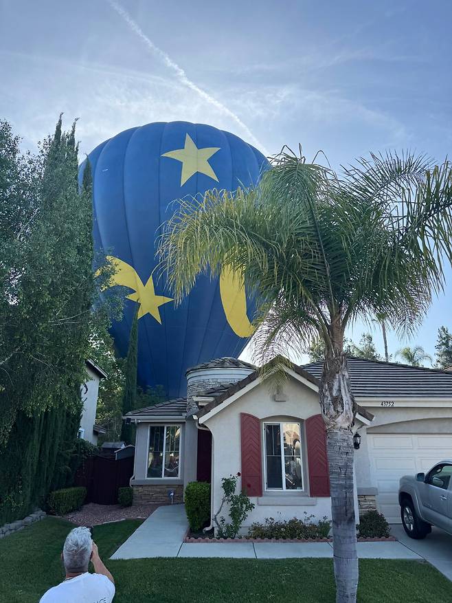 18일(현지시간) 미국 캘리포니아주 테메큘라의 한 주택 뒷마당에 13명을 태운 열기구가 비상 착륙해 멈춰 서 있다. 사진= AP(뉴시스)