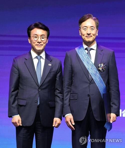 김민석 국무총리가 21일 서울 강남구 한국과학기술회관에서 열린 2026 과학·정보통신의 날 기념식에서 김정상 듀크대학교 석좌교수에게 정부 포상을 시상한 뒤 기념사진을 찍고 있다. [연합뉴스]