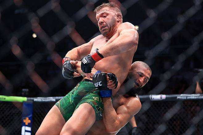 함자트 치마예프(오른쪽)가 지난 해 8월 UFC 319에서 당시 챔프 드리커스 뒤 플레시스를 뒤에서 들어 메치고 있다. 치마예프는 이 경기에서 승리하며 미들급 새 챔피언이 됐다. [게티이미지]