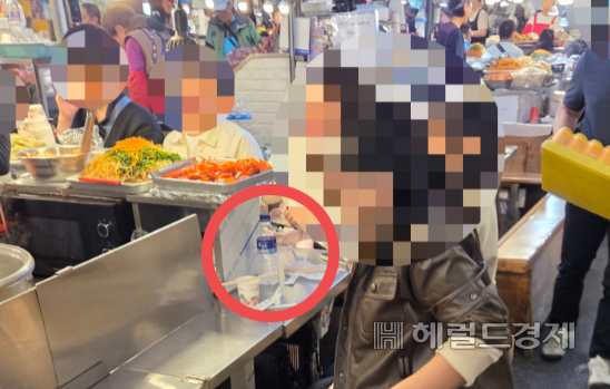 지난 20일 오전 서울 종로구 광장시장의 한 노점에 앉은 외국인 관광객 앞으로 생수병이 놓여있다. 이영기 기자.