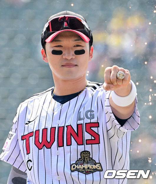 [OSEN=잠실, 지형준 기자] 28일 서울 잠실야구장에서 2026 신한 SOL KBO리그 개막전 LG 트윈스와 KT 위즈의 경기가 열렸다. 이날 LG는 요니 치리노스, KT는 맷 사우어를 선발로 내세웠다.LG 박해민이 김인석 대표이사에게 통합우승 반지를 전달받고 있다. 2026.03.28&nbsp;/ jpnews@osen.co.kr