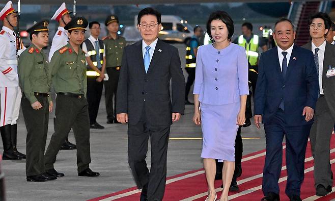 하노이 도착 베트남을 국빈 방문한 이재명 대통령과 김혜경 여사가 21일 하노이 노이바이 국제공항에 도착해 이동하고 있다. 이 대통령은 이날부터 24일까지 또럼 당서기장 겸 국가주석과 팜민찐 총리, 쩐타인먼 국회의장 등을 만나며 경제·안보 분야 협력 강화 논의에 나선다. 하노이=남정탁 기자