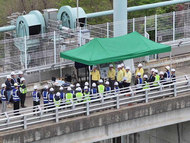 4월 22일 용담댐 정상부에서 장병훈 부문장을 비롯한 현장 관계자들이 시설 현황 등에 대한 설명을 듣고 만반의 대응 태세를 갖추고 있다.