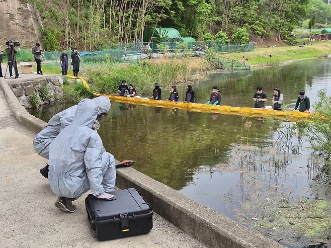 울산시가 22일 오후 환경오염사고에 신속히 대응하기 위해 유형별 환경오염사고 대비 유관기관 합동 방제훈련을 진행했다. 사진은 시 환경대기과에서는 화학보호복을 착용한 채 긴급히 사고물질 농도 및 대기오염도 측정과 함께 하천수 시료를 채취하고 있다.