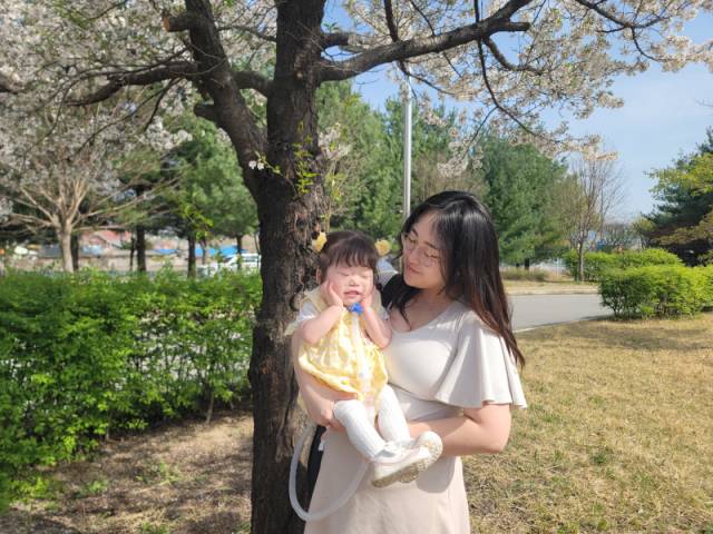 ▲ 지난 10일 춘천의 공공어린이재활센터에서 남경아 씨와 딸 시은이가 봄을 만끽하고 있다. 자가 호흡이 어려운 시은이는 이동 때마다 인공호흡기를 구비해야 한다. 경아 씨는 아이와 인공호흡기를 합한 무게 15㎏를 감당하며 이동에 나선다.