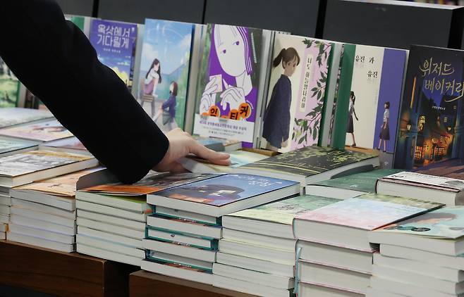 A person picks a book at a bookstore in Seoul on Nov. 13, 2025. [YONHAP]