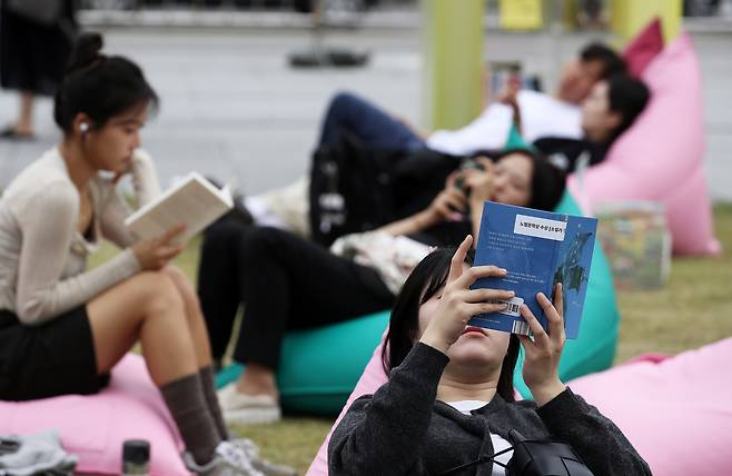 People read at an outdoor library set up by the Seoul Metropolitan Government at Gwanghwamun Square in Jongno District, central Seoul, on Oct. 13, 2024. [NEWS1]