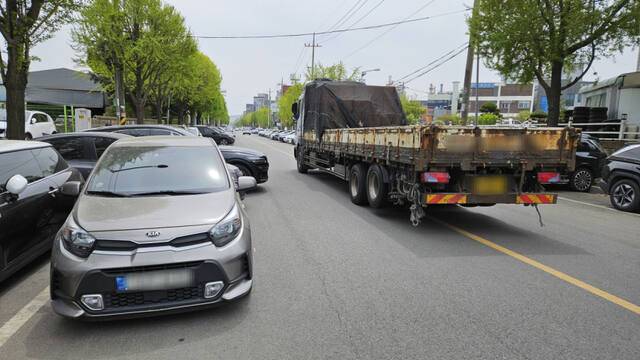 21일 인천 서구 한 공업지역. 직각주차, 이중주차 등 불법주차 차량을 피해 한 화물차가 중앙선을 밟고 지나고있다. 박기웅기자