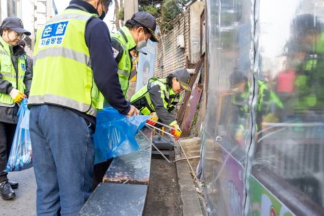 주민과 공무원들이 봄맞이 대청소를 실시하며 도로변과 무단투기 지역을 정비하고 있다. 마포구청 제공