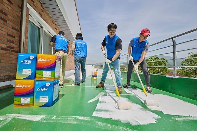 직원들이 옥상에 KCC의 백색 차열 페인트 스포탄 상도를 바르고 있다. 이 소재에는 열기 축적을 줄이는 쿨루프 공법이 도입됐다. [KCC]