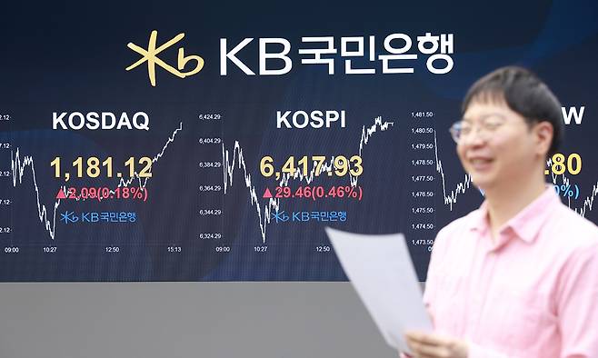 오늘도 웃었다 코스피가 사상 처음으로 6400선을 넘어선 22일 서울 여의도 KB국민은행 딜링룸 전광판에 종가가 표시되고 있다. 이날 지수는 전장보다 29.46포인트(0.46%) 오른 6417.93에 마감하며 이틀 연속 최고치를 갈아치웠다. KB국민은행 제공