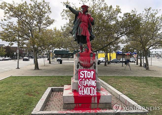 '집단학살 기념을 멈추라'는 팻말이 놓인 미국의 콜럼버스 동상 [AP=연합뉴스 자료사진]