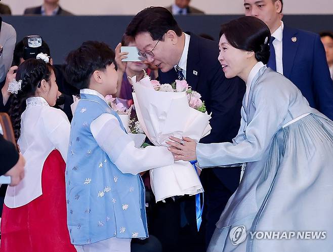꽃다발 받는 이재명 대통령 부부 (하노이=연합뉴스) 김도훈 기자 = 베트남을 국빈 방문 중인 이재명 대통령과 김혜경 여사가 22일(현지시간) 하노이의 한 호텔에서 열린 동포간담회에서 화동으로부터 꽃다발을 받고 있다. 2026.4.22 superdoo82@yna.co.kr