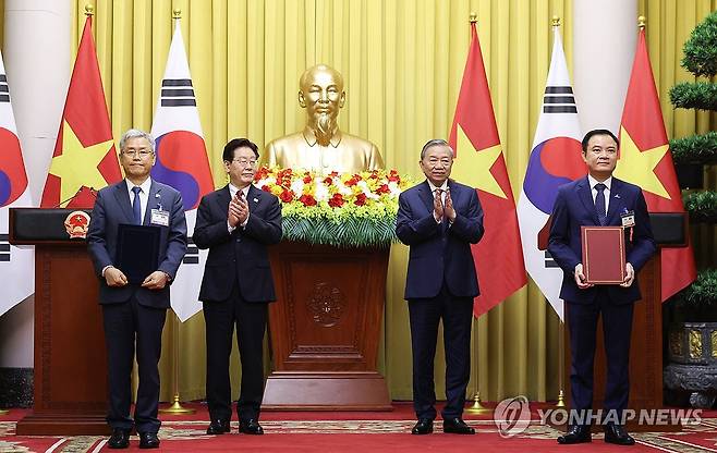 한-베트남, 원전 개발 협력 (하노이=연합뉴스) 김도훈 기자 = 김동철 한국전력공사 사장과 레 응옥 썬 베트남 국가산업에너지공사(PVN) 회장이 22일(현지시간) 하노이 주석궁에서 이재명 대통령과 또 럼 공산당 서기장 겸 국가주석이 임석한 가운데 원전 개발 협력 가능성 검토 양해각서(MOU) 교환 후 기념촬영을 하고 있다. 2026.4.22 superdoo82@yna.co.kr