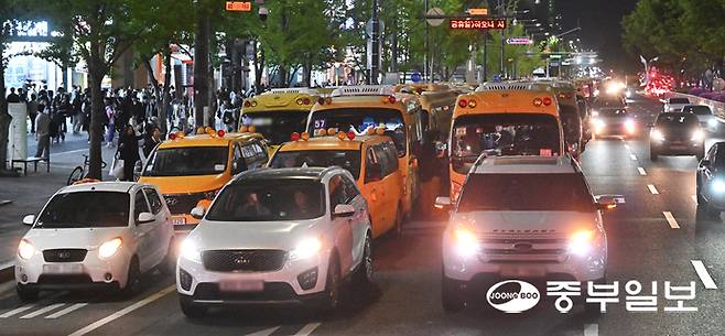 지난 22일 오후 10시께 안양시 동안구 학원가 일대에 3개 차선에 걸쳐 무단주차된 학원 차량들로 인해 다른 차량들이 정체를 겪는 모습. 김경민기자