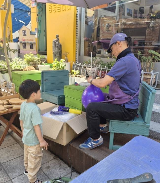 골목 페스타에 참여한 한 아이가 풍선을 기다리고 있다. /최은주 기자
