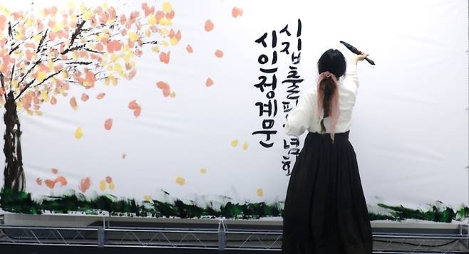 ▲ 캘리그래피 작가 조서연이 17일 의성읍 온누리터 2층 대회의실에서 열린 정계문 시집 출판기념회에서 붓글씨 퍼포먼스를 선보이고 있다. 정계문 시인 제공
