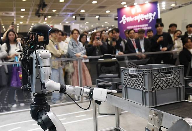 지난 22일 서울 강남구 코엑스에서 열린 '2026 월드IT쇼(WIS 2026)'를 찾은 관람객들이 KT 부스에서 K-RaaS 플랫폼을 활용한 산업 현장 피지컬 AI 시연을 지켜보고 있다. /사진=뉴스1