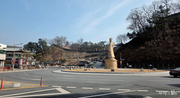 공산성 회전교차로 앞의 백제 중흥군주 무령왕 동상_문서 두루마리를 들고 곤룡포 소매를 휘날리며 금강 건너 북쪽을 가리키고 있다. 뒤로 공산성 서문, 앞에 공산정이 보인다.