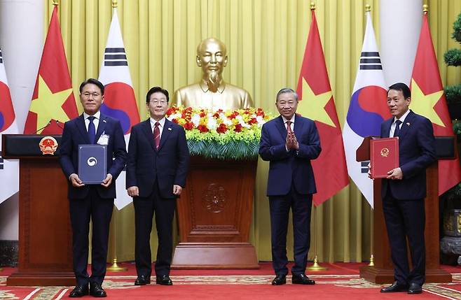 황인권 대통령경호처장과 르엉 땀 꽝 공안부 장관이 지난 22일(현지 시간) 베트남 하노이 주석궁에서 이재명 대통령과 또 럼 베트남 당 서기장 겸 국가주석이 임석한 가운데 경호안전 분야 협력에 관한 양해각서를 교환한 후 기념촬영을 하고 있다. 뉴시스