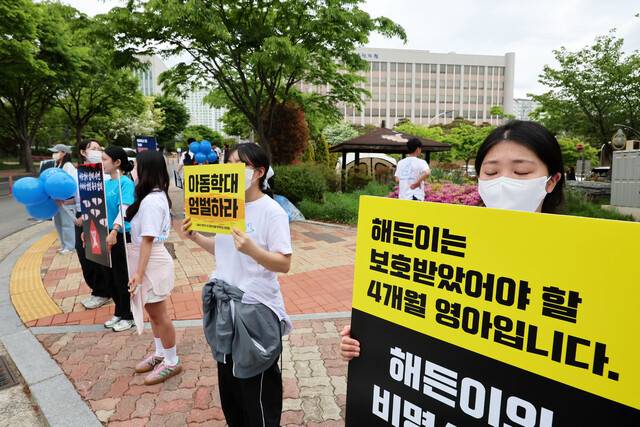 23일 전남 순천시 광주지방법원 순천지원 앞에서 해든이 추모 집회 참가자들이 생후 4개월 아들을 학대해 숨지게 한 혐의를 받는 친모에 대해 엄벌을 촉구하는 손팻말을 들고 있다. 연합뉴스