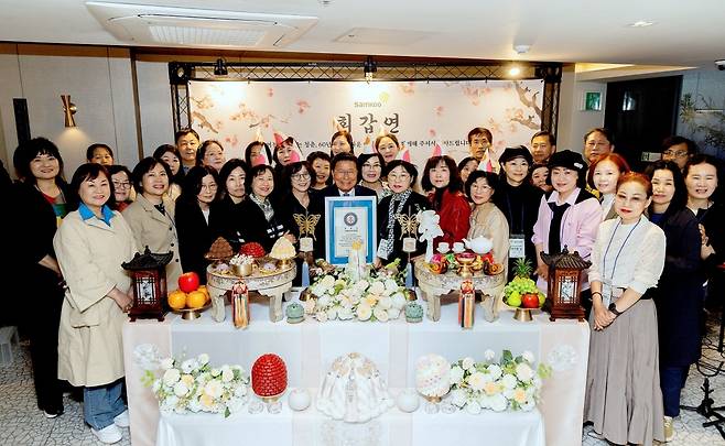 구자관 삼구아이앤씨 책임대표사원(앞줄 왼쪽에서 일곱번째)과 환갑을 맞이한 구성원들이 한국기록원 공식 인증서를 수여했다. 삼구아이앤씨 제공