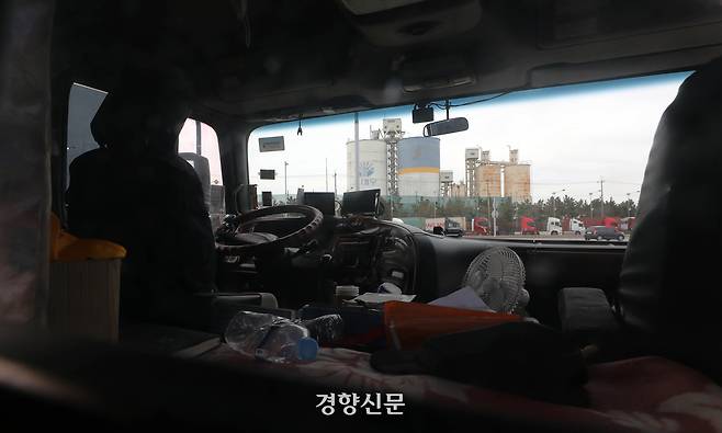 화물연대 총파업 11일째인 2022년 12월4일 시멘트 업체가 모여있는 인천 중구 서해대로 가변 주차장에 운행을 멈춘 화물연대 화물차량 운전석 너머로 한 시멘트 업체가 보이고 있다. 김창길 기자
