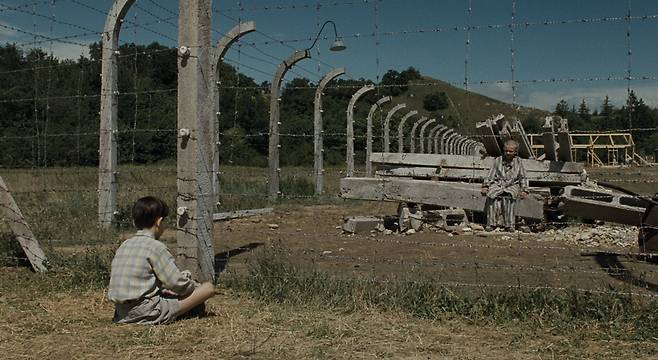 영화 <줄무늬 파자마를 입은 소년>의 두 소년이 철조망을 사이에 두고 서로를 바라보고 있다.   팝엔터테인먼트 제공