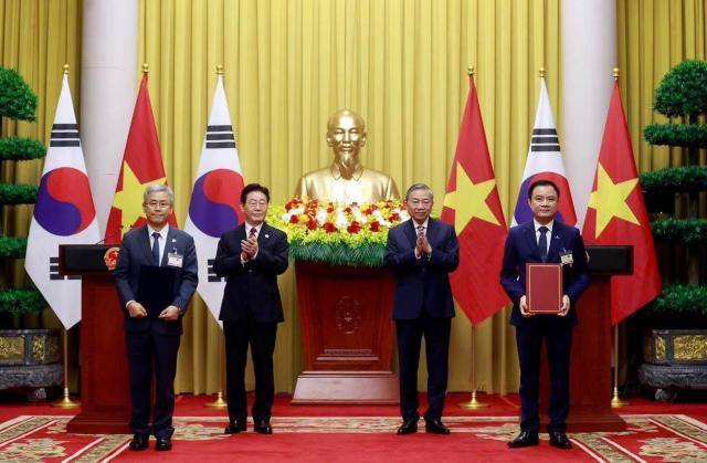 김동철 한국전력 사장이 레 응옥 손 베트남 국가산업에너지공사 회장과 양국 정상이 배석한 가훈데 '원전 개발 협력 가능성 검토 업무협약(MOU)'를 체결한 뒤 기념 촬영을 하고 있다.[사진=한국전력]