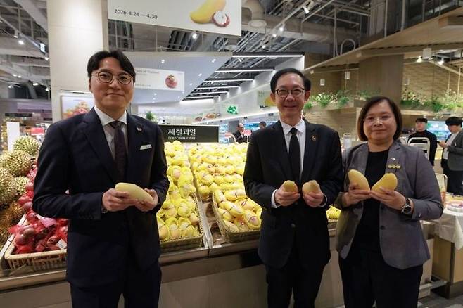 주한태국상무공사관과 현대백화점이 함께 개최하는 'Taste of Thailand 2026' 프로모션에서 3명의 관계자가 태국산 프리미엄 망고를 선보이고 있다. (좌측부터) 현대백화점 더현대 서울 식품팀 양재모 수석, 주한태국대사관 차와돈 나파탄논 공사, 주한태국상무공사관 싸이텅 써이펫 상무관.