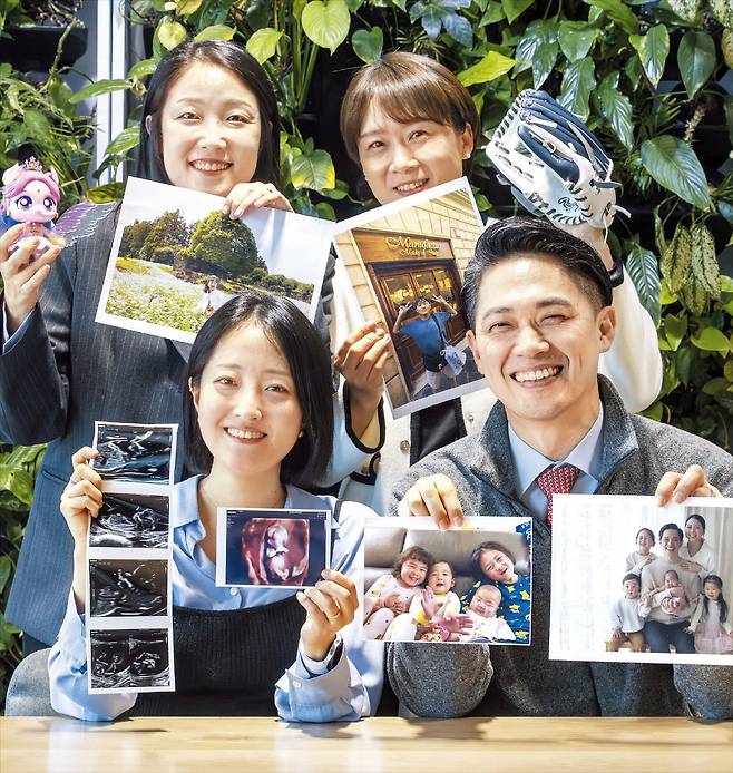 지난 22일 서울 강남구 메드트로닉코리아 사무실에서 직원들이 자녀 사진을 들고 활짝 웃고 있는 모습. 이 회사는 가족 돌봄 휴가와 재택근무 등을 통해 아이를 키우는 직원들을 지원하고 있다. /김지호 기자