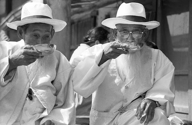 오랜만에 친구를 만나 막걸리를 마시는 할배들, 1991, 충북 영동장./ 사진가 정영신