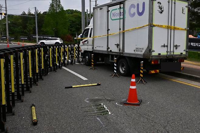 22일 오전 경남 진주시 정촌면 BGF로지스 진주센터 인근 사고 현장에는 사고 화물차량이 세워져 있고, 그 옆에는 사고로 숨진 A조합원을 추모하는 조화가 놓여 있다.ⓒ뉴시스