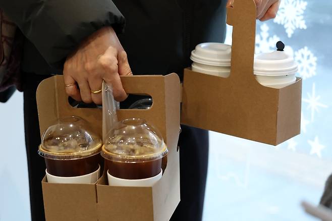 서울 시내의 한 카페에서 고객이 일회용 컵에 담긴 커피를 들고 가고 있다. 뉴시스