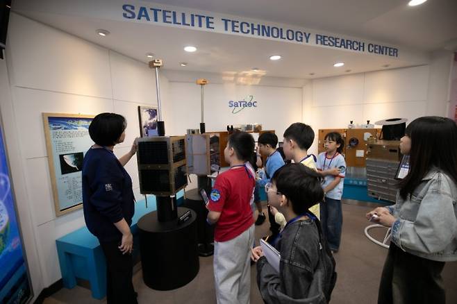 KAIST 우주연구원에서 개발한 우리별 1호의 모형을 보고 있는 어린이 기자들. 스튜디오51 제공