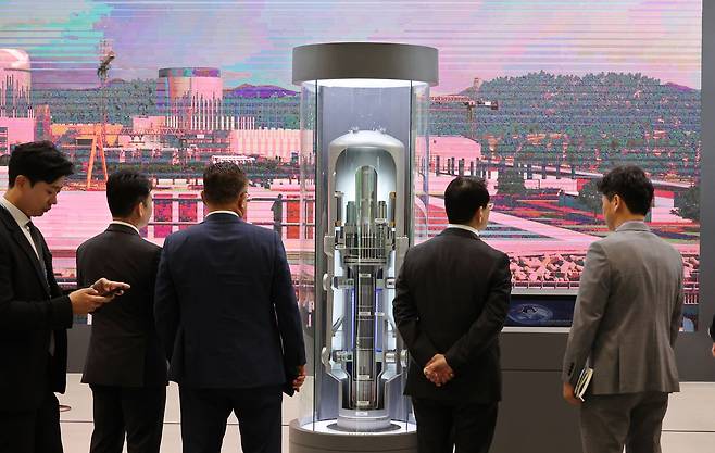 지난 22일 부산 해운대구 벡스코 제1전시장에서 개막한 '2026 부산국제원자력산업전'에서 관람객들이 혁신형 소형모듈원전(I-SMR) 모형을 살펴보고 있다.   24일까지 열리는 이번 행사에는 19개국의 전력, 원자력 관련 기업 130곳이 참가해 소형모듈원자로(SMR) 등 세계 원전 시장의 최신 기술을 소개하며, 한국원자력연차대회와 제25차 태평양연안국 원자력회의가 동시에 개최된다. 연합뉴스