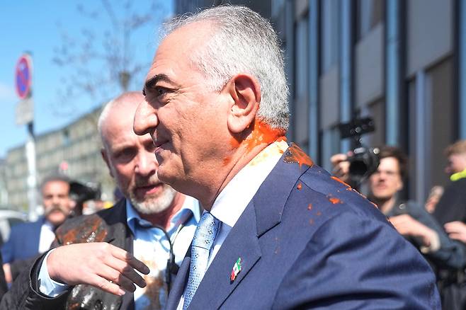 미국에 망명 중인 레자 팔레비 전 이란 왕세자가 23일(현지 시간) 독일 베를린에서 미국과 이란의 휴전을 비난하는 기자회견을 마친 후 붉은 액체 테러를 당했다. AP연합뉴스