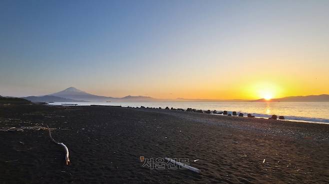검은 모래와 흑송숲으로 유명한 일본 시즈오카 남단의 미호노 마쓰바라 공원 모습. 동틀녘에 더 검게 느껴지는 모래와 햇살을 받아 검붉게 변한 후지산이 절경을 펼쳐 내고 있다.